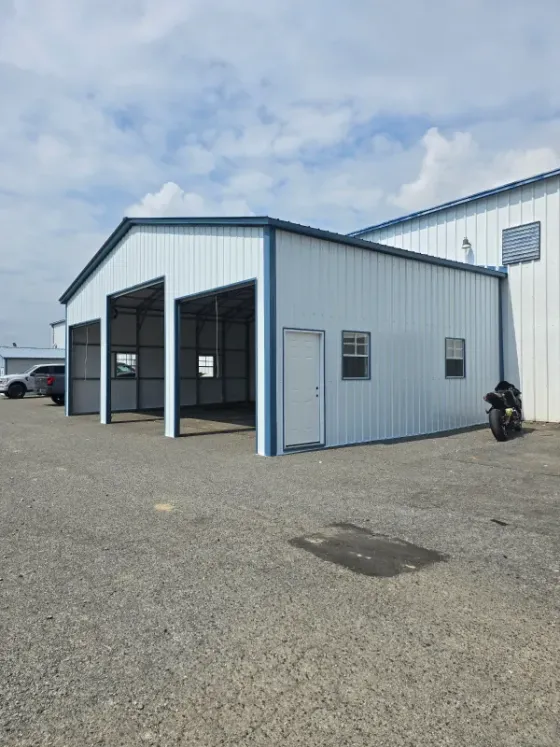 A white building with a motorcycle parked in front of it.