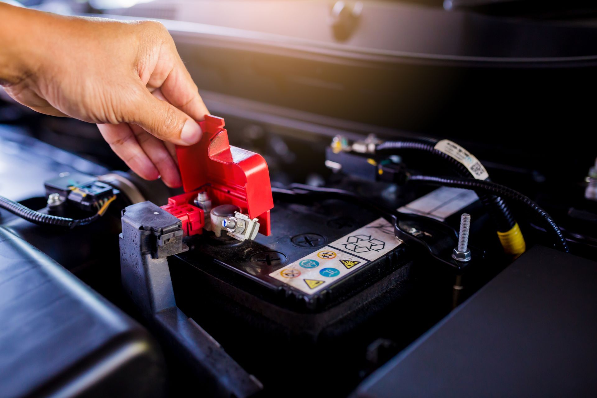 A person is plugging a battery into a car.