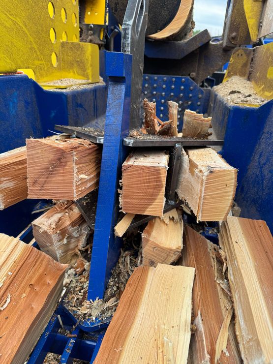 A pile of wood is being processed in a machine.