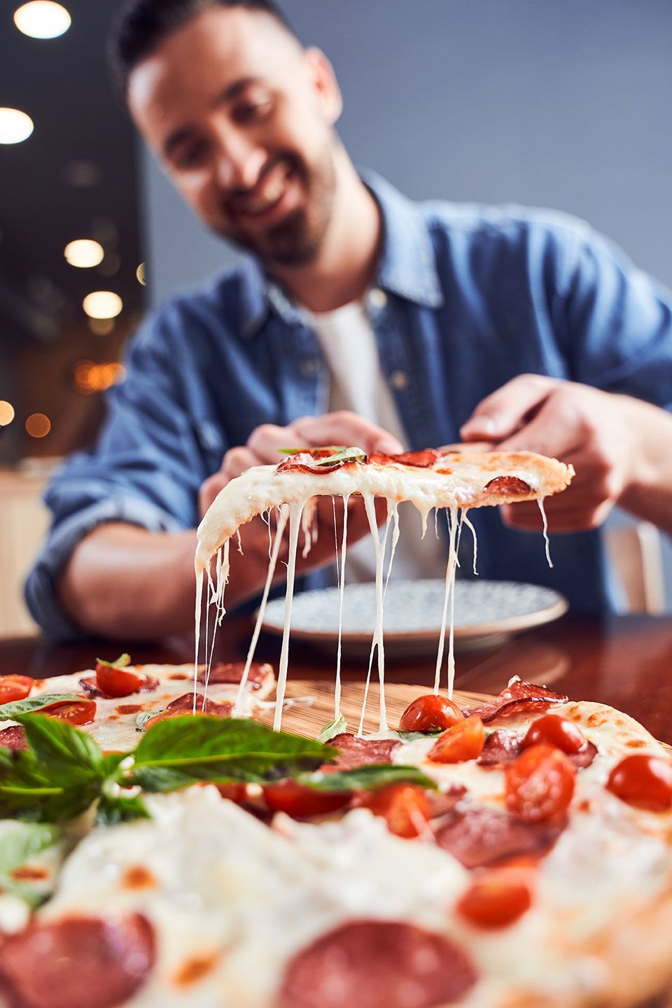Low angle shot of Man with beard eating tasty pizza