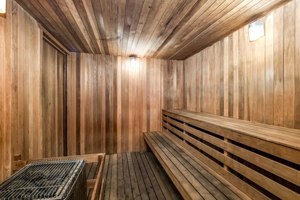 Wood-paneled sauna interior with benches and a heater.
