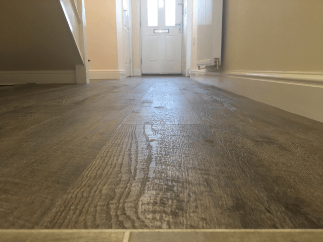 wooden flooring in a hallway to a door