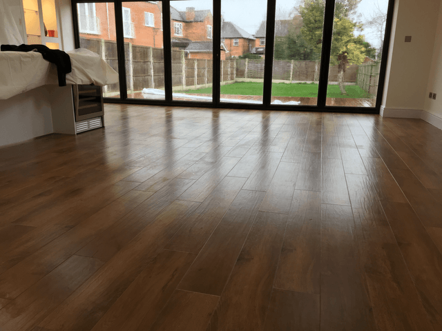 wooden flooring leading to glass patio doors and garden beyond