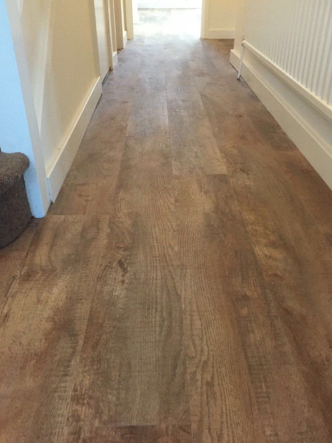 wood flooring in a hallway with a carpeted staircase