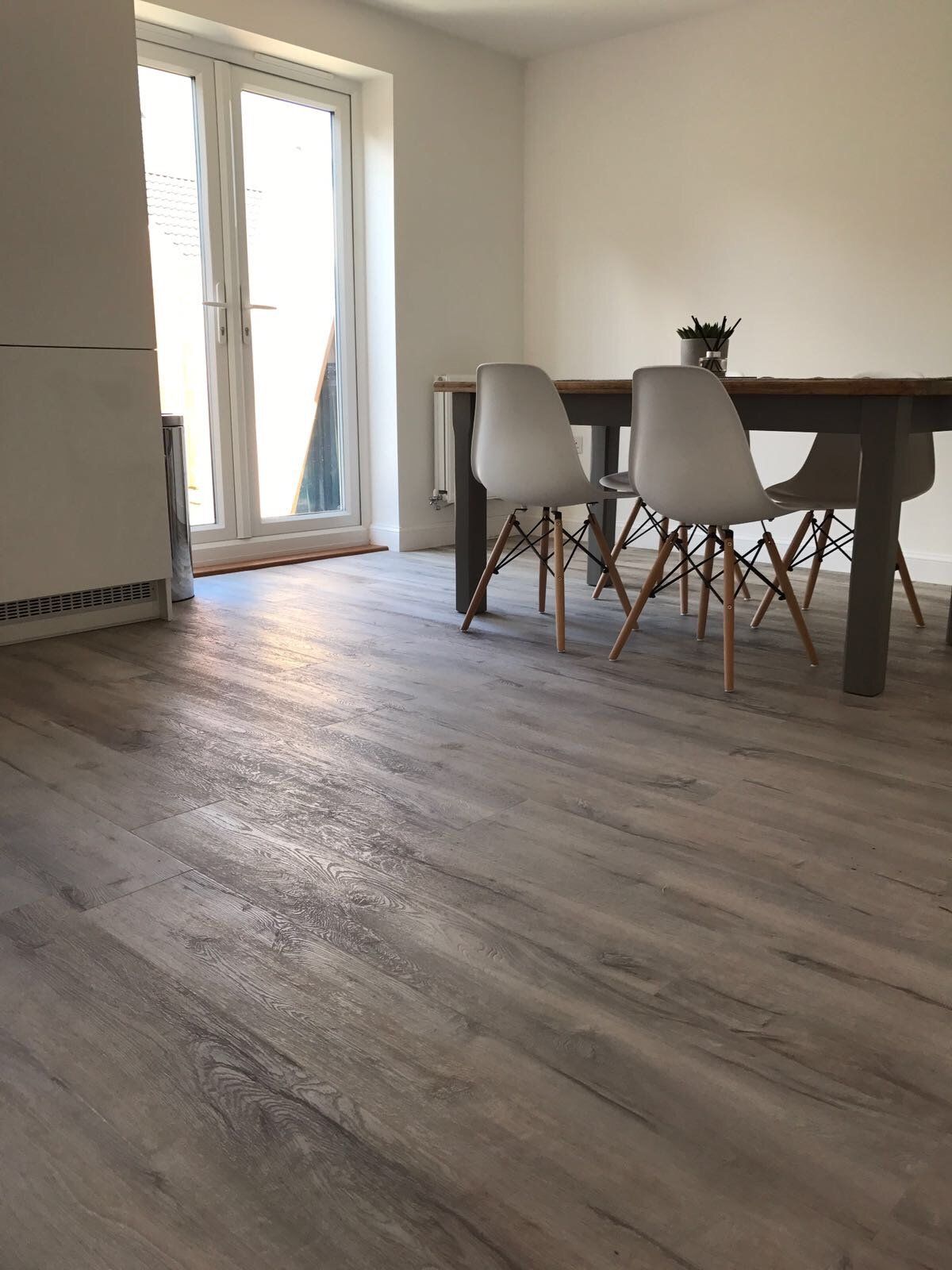 wooden flooring in a dining room with table and chairs