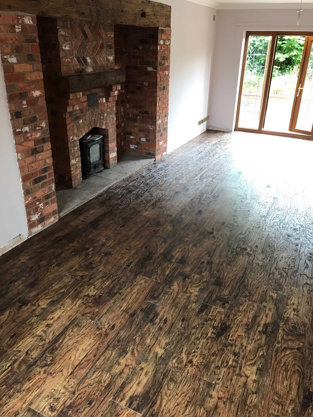 real wood flooring next to a brick fireplace