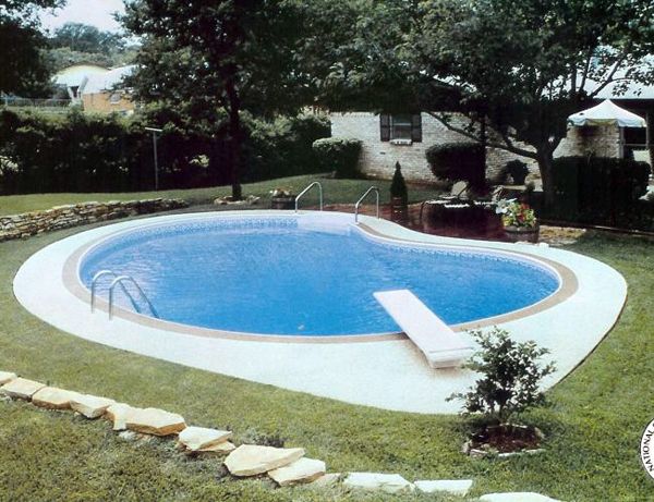 A swimming pool with a diving board in the backyard