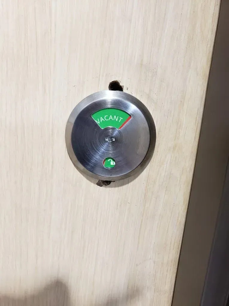A close up of a door lock with a green indicator on it.