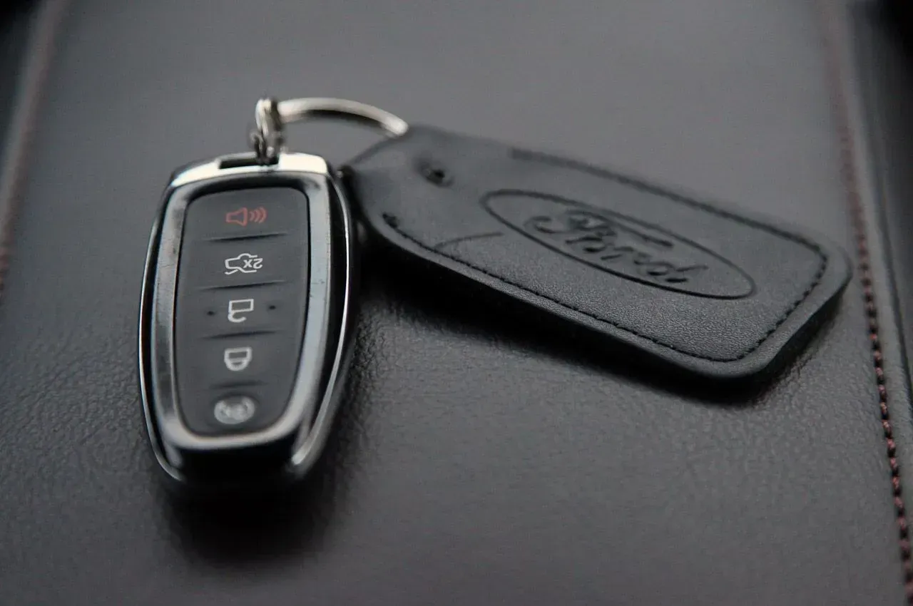A close up of a ford key fob on a black surface.