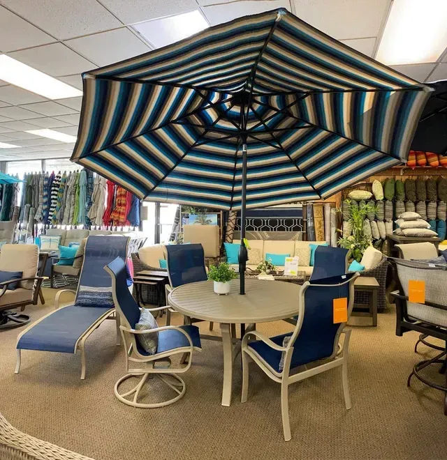 A Large Striped Umbrella Is in The Middle of A Room Filled with Furniture
