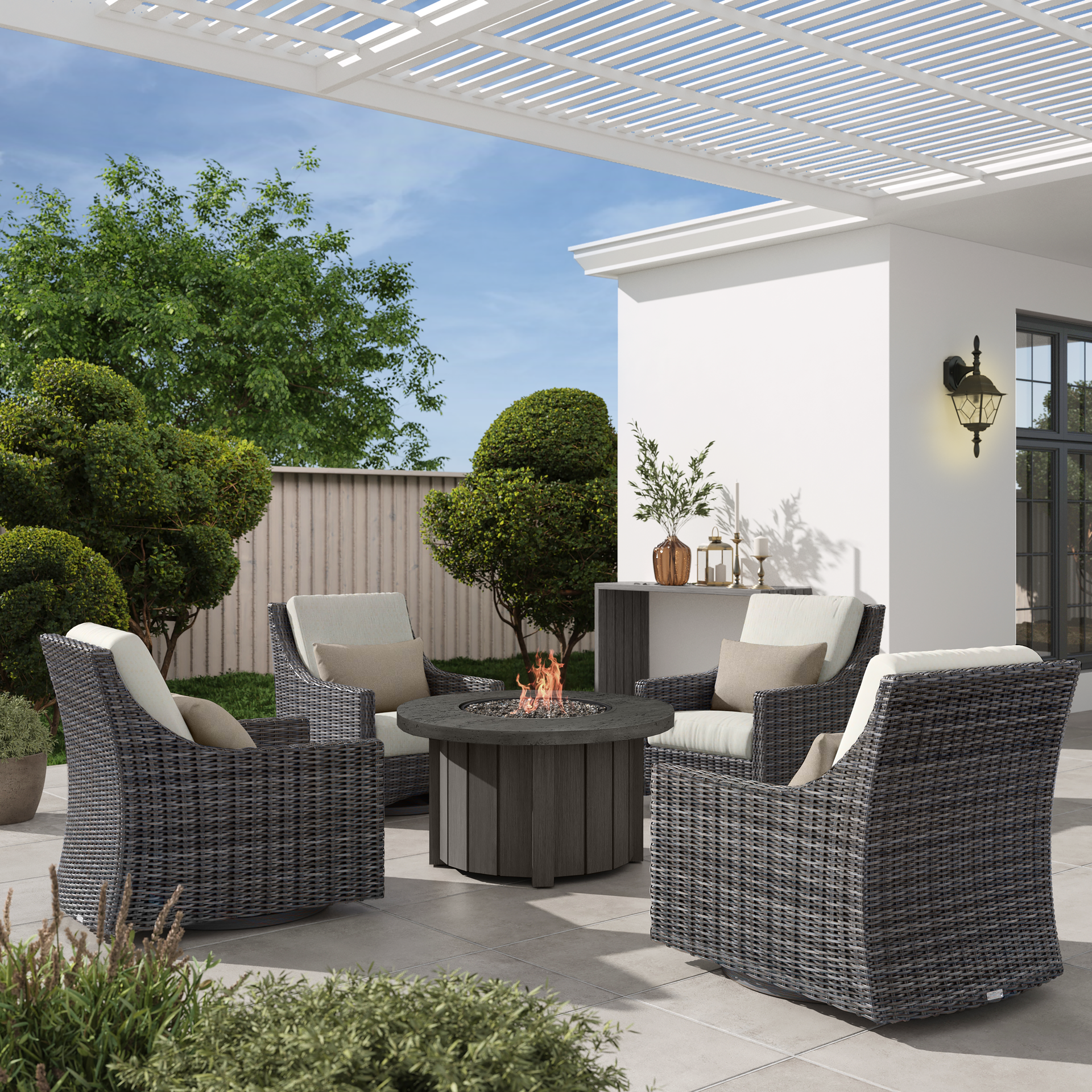 Patio set with four gray wicker chairs around a fire pit on a sunny day.