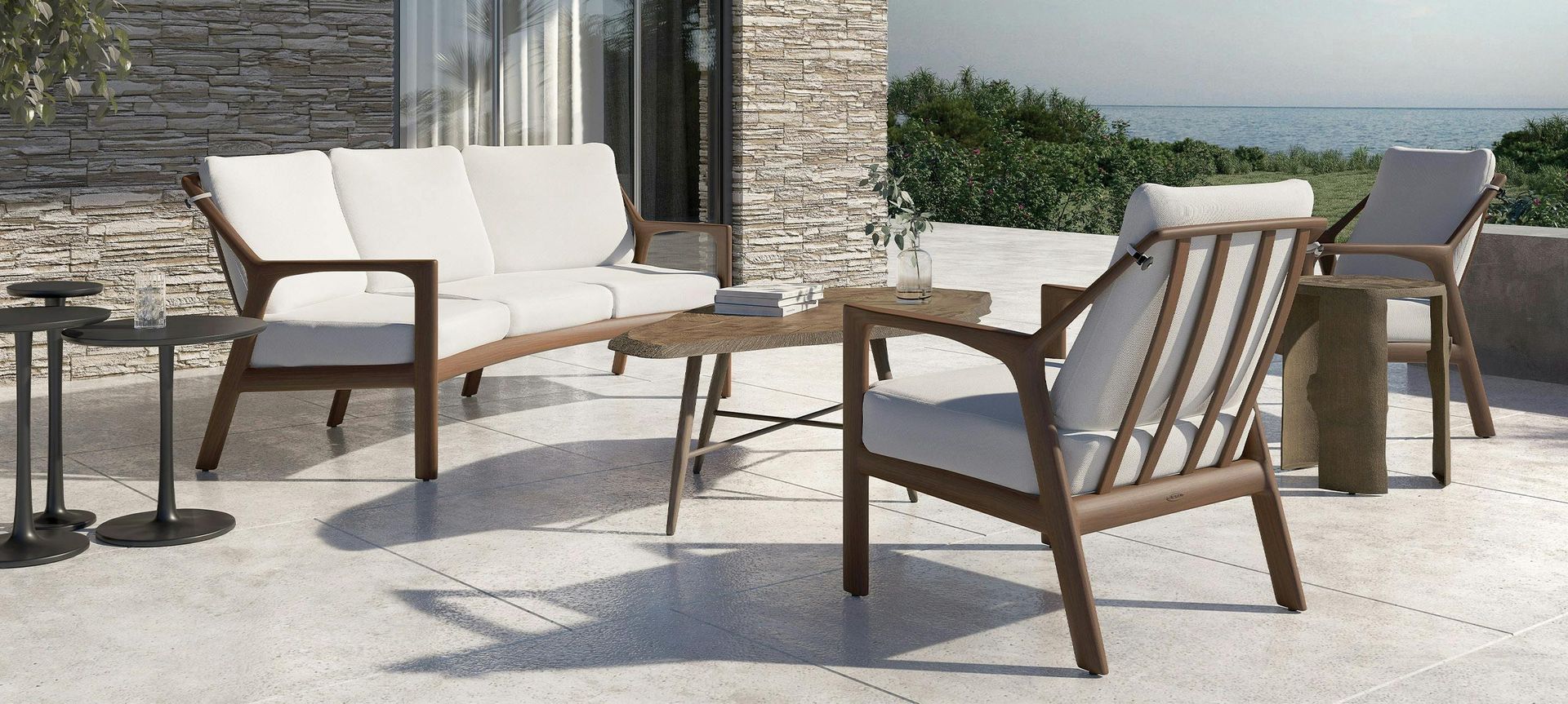 A patio with a couch , chairs , and a table with a view of the ocean.