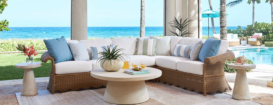 A living room with a couch and a table with a view of the ocean.