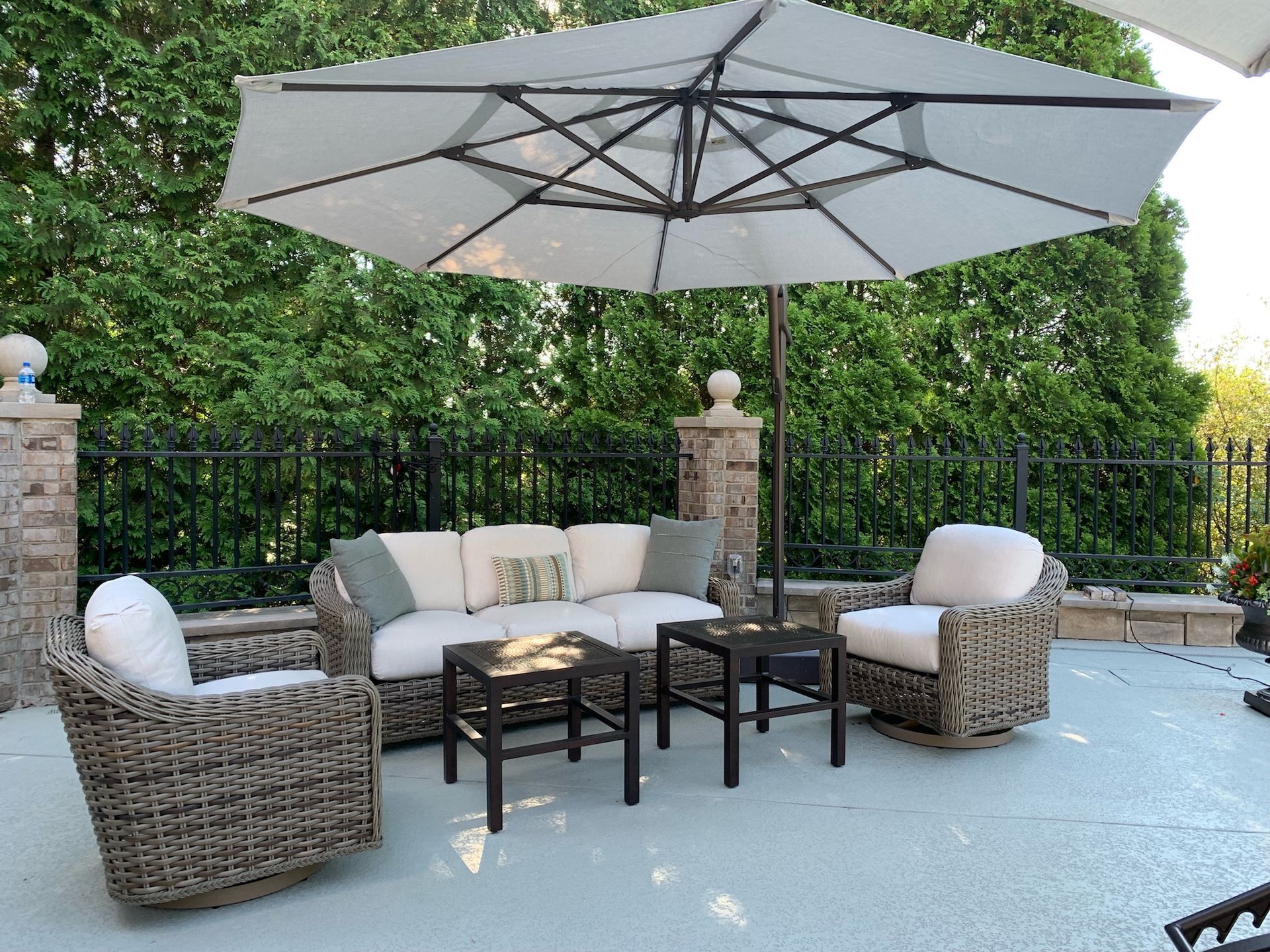 A patio with wicker furniture and a large umbrella