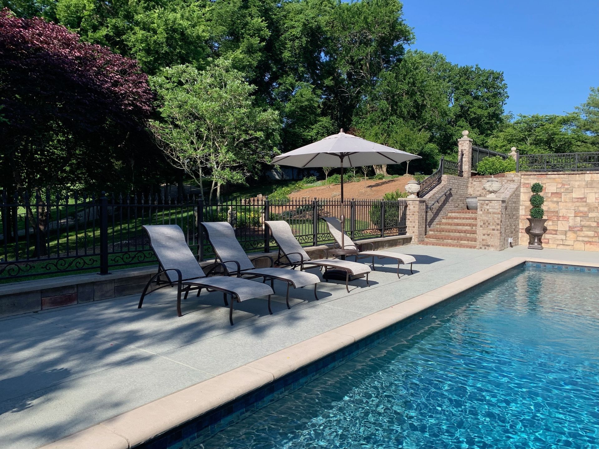 A swimming pool with chairs and umbrellas around it