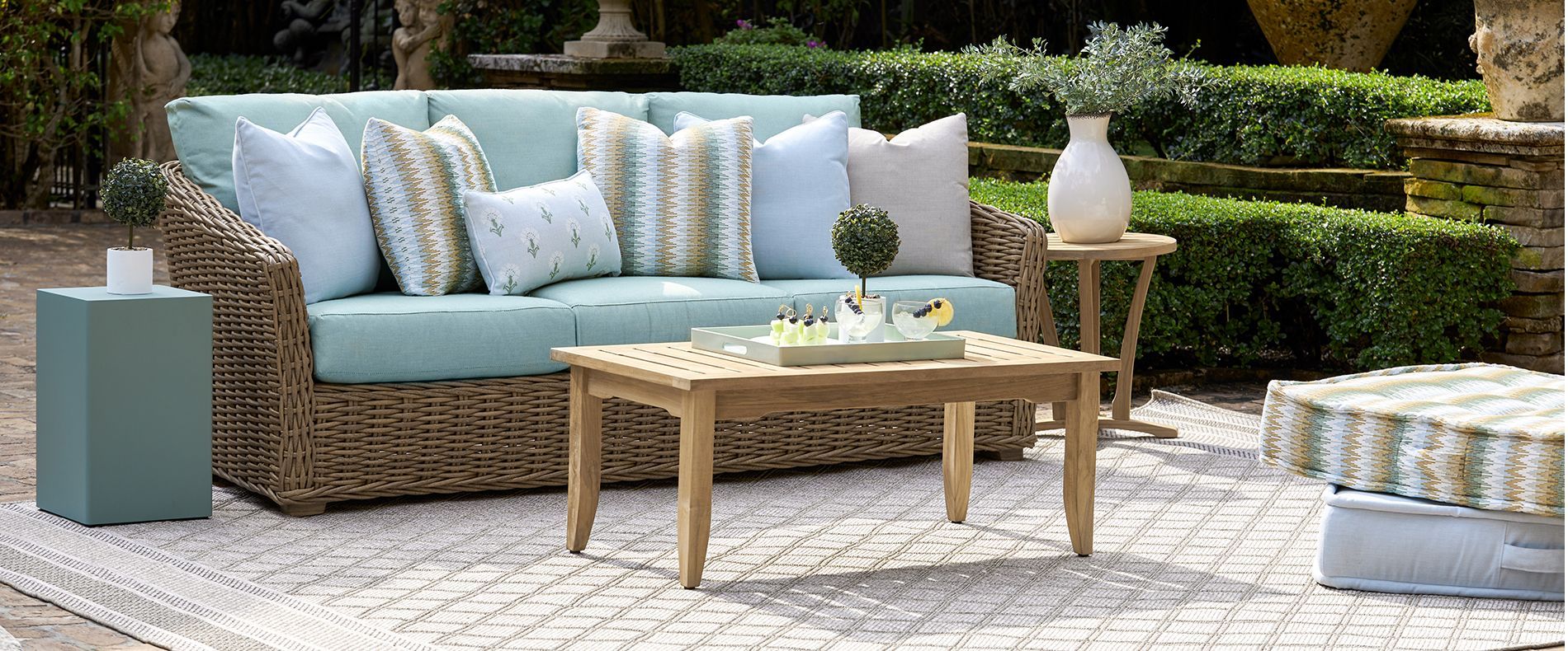 A wicker couch is sitting next to a wooden coffee table.