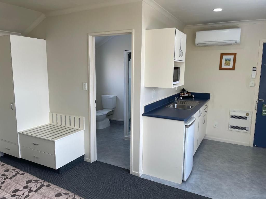 There is a bathroom and a kitchen in the room.