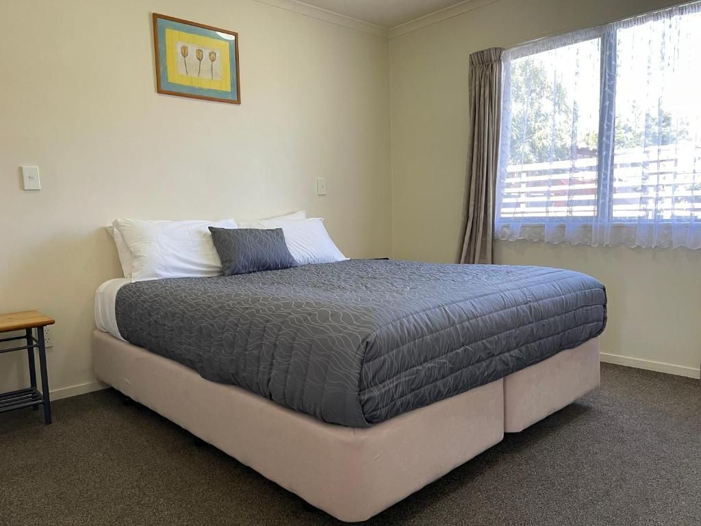 A bedroom with a large bed and a window.