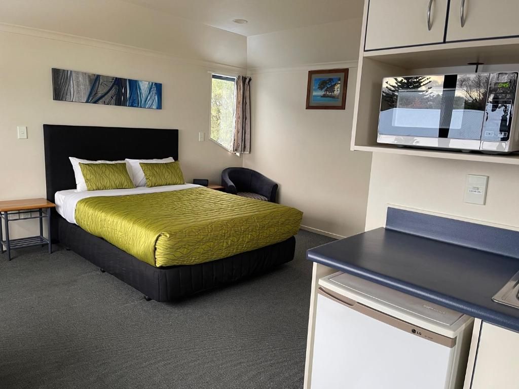 A hotel room with a king size bed and a microwave.