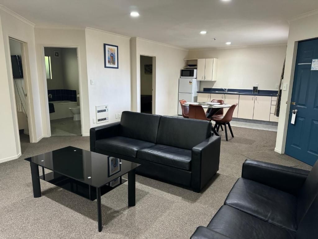 A living room with a couch , table and chairs.