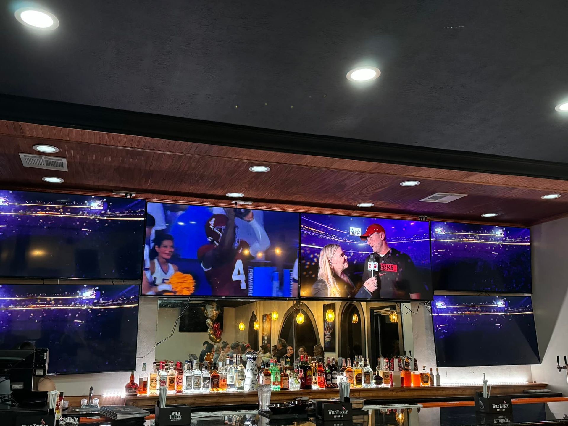 A bar with a lot of televisions on the wall
