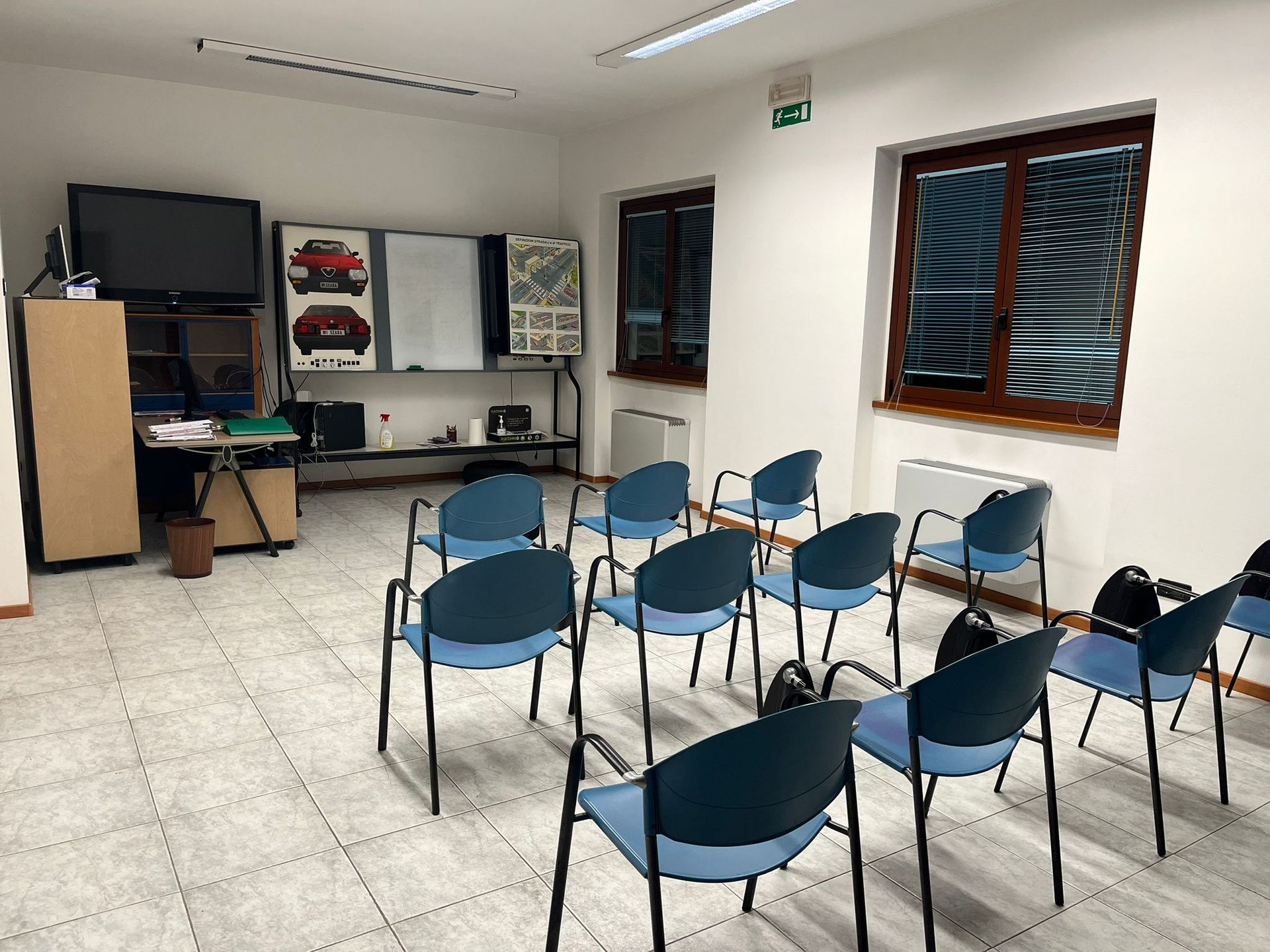 Un'aula con file di sedie e una lavagna con l'immagine di un'auto.