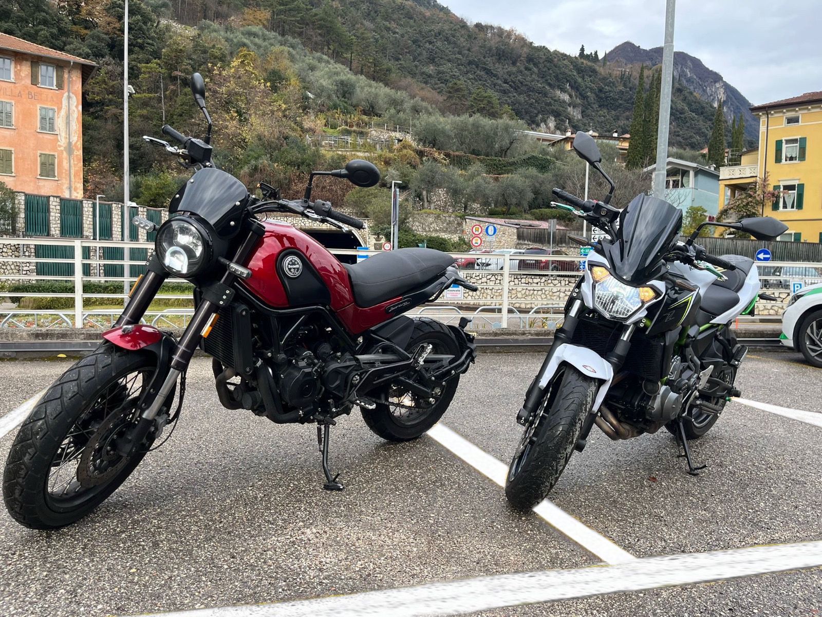Due motociclette sono parcheggiate una accanto all'altra in un parcheggio.