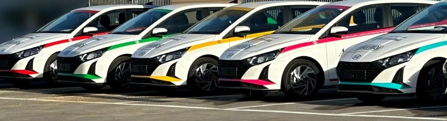 Una fila di auto colorate sono parcheggiate una accanto all'altra in un parcheggio.