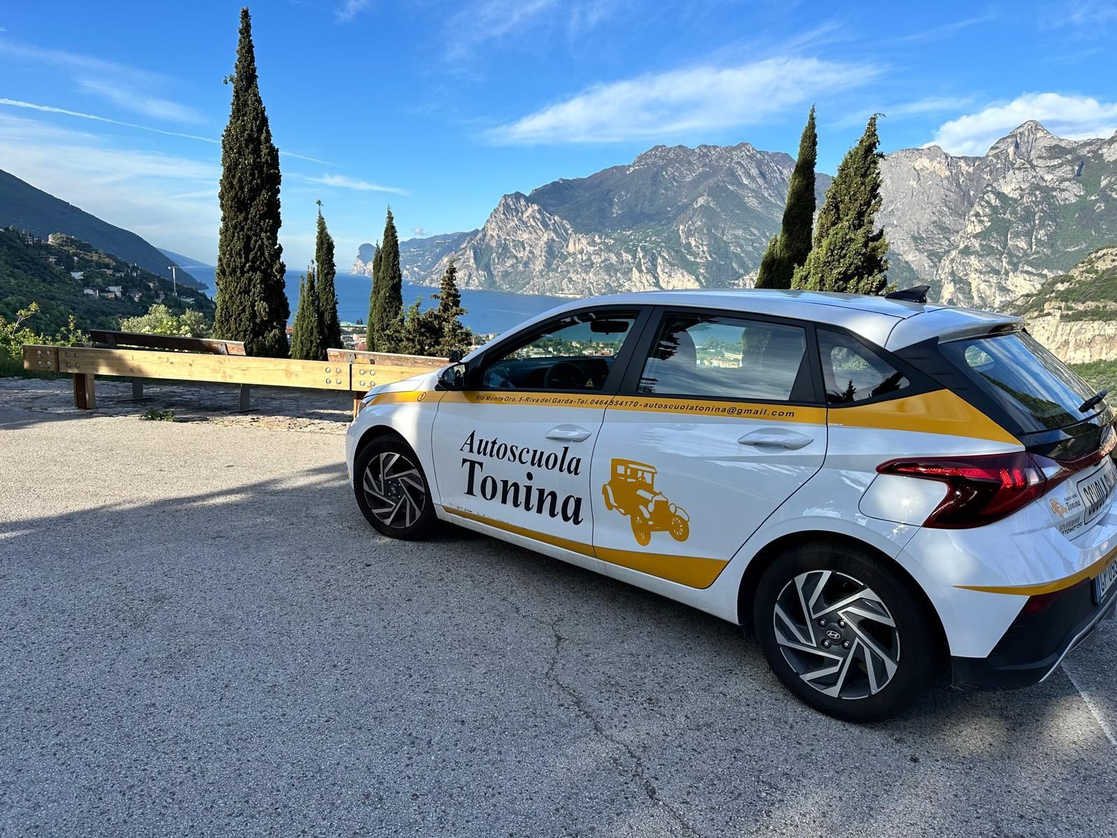 Un'auto bianca e gialla è parcheggiata sul ciglio della strada.