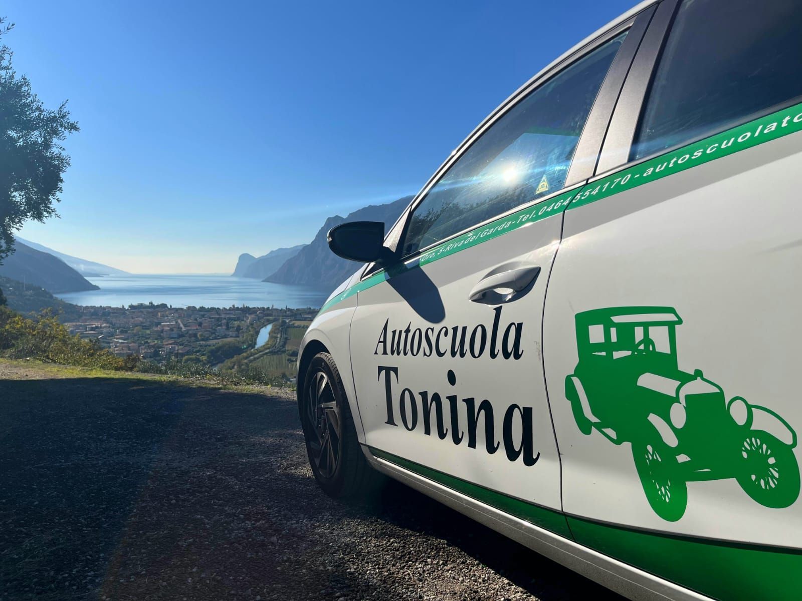 Un'autoscuola tonina bianca e verde è parcheggiata sul ciglio della strada