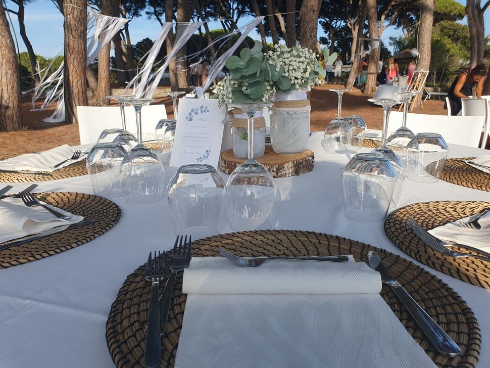 Tavolo per ricevimento di nozze allestito all'aperto con tovaglia bianca