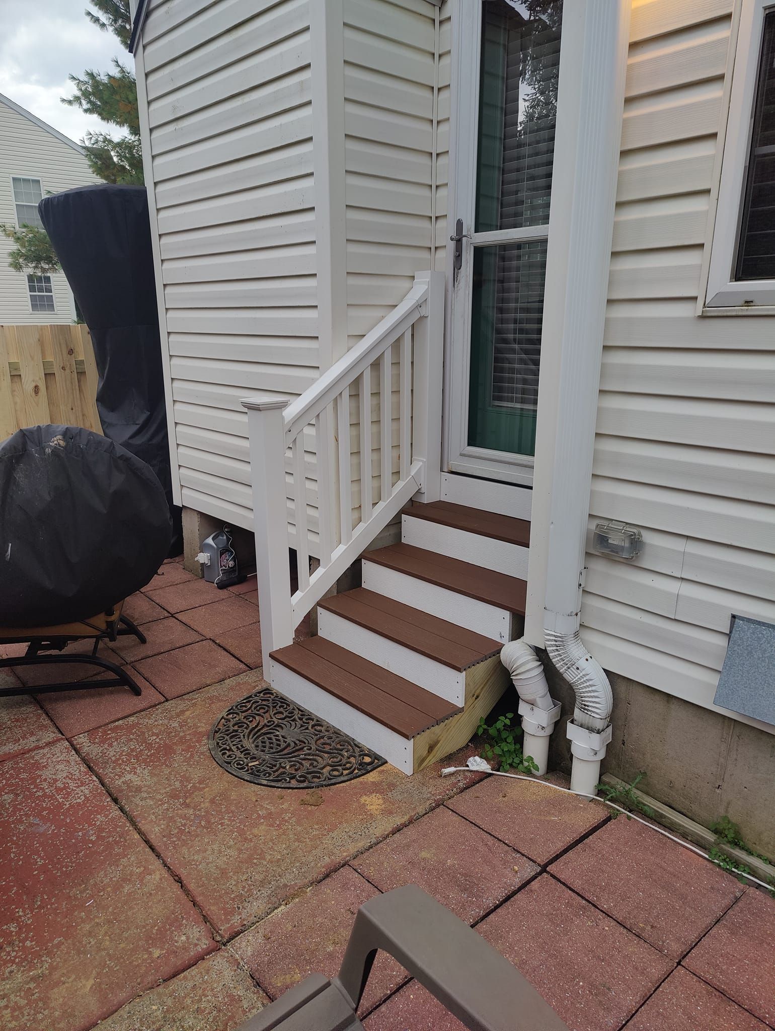 A white house with stairs leading up to the front door.