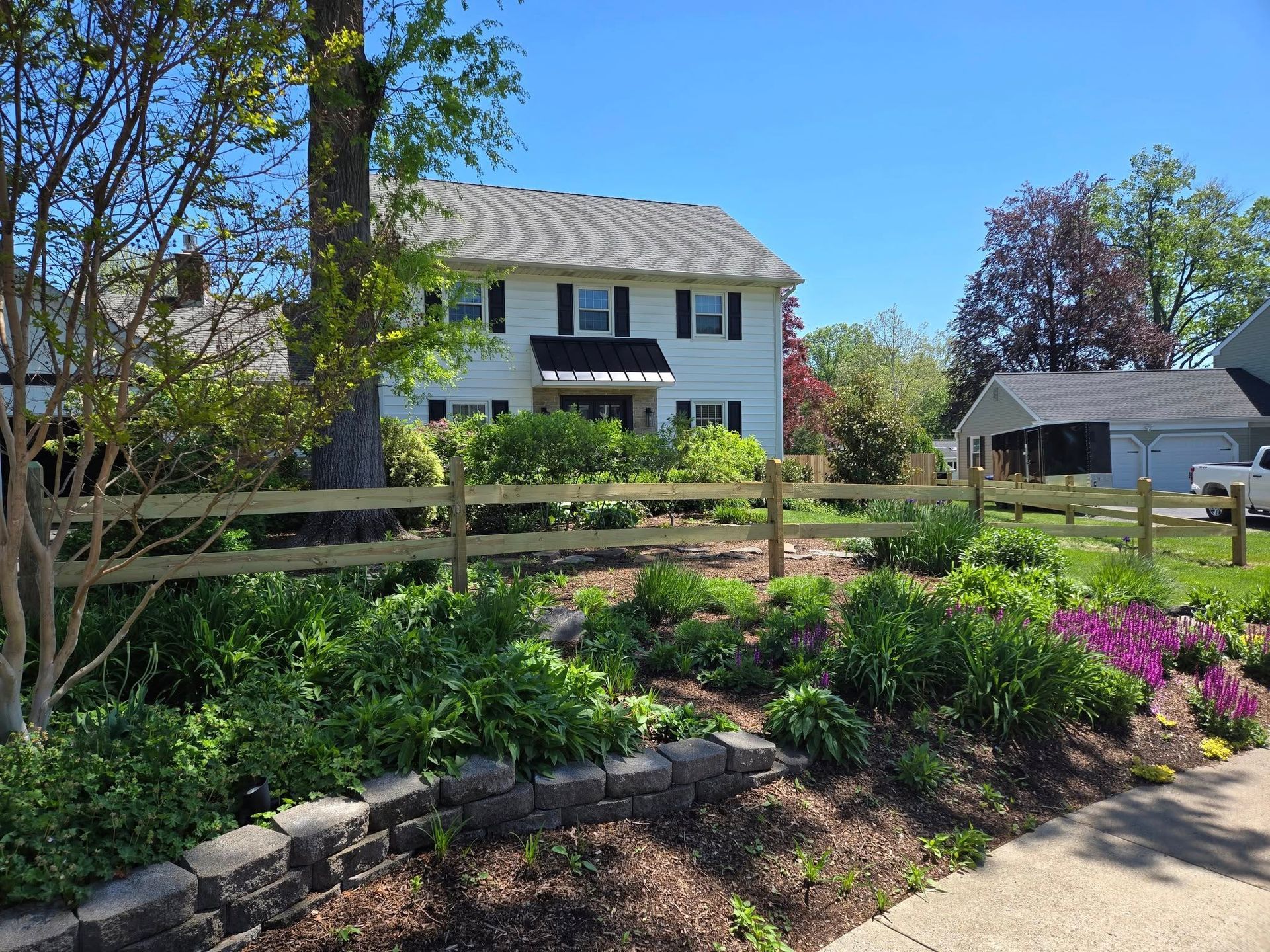 A white house with a wooden fence in front of it