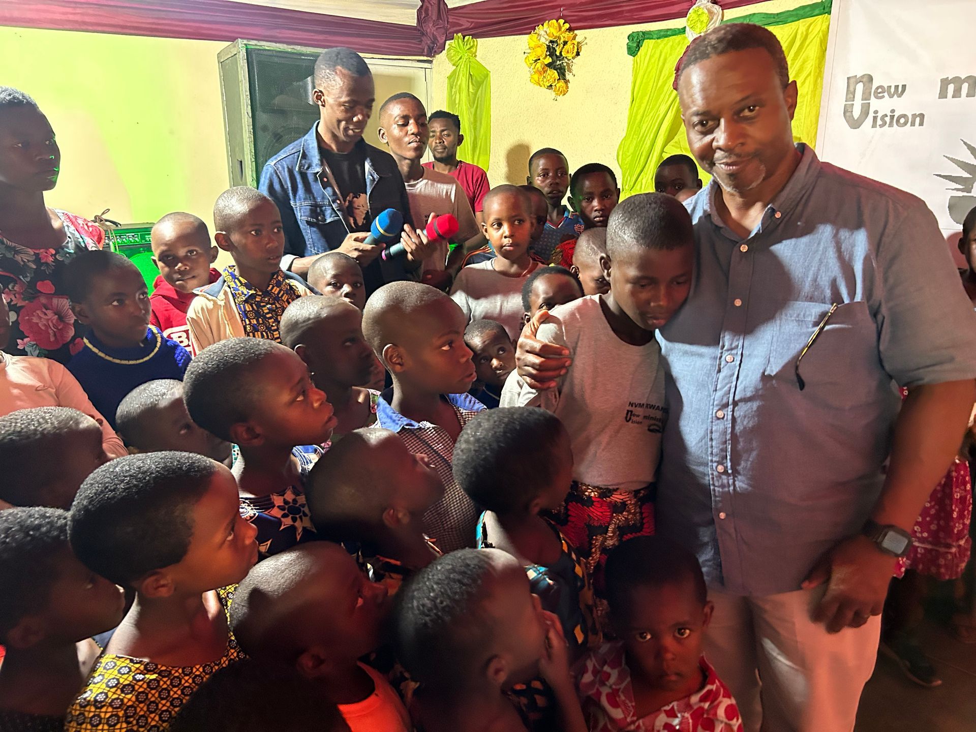 a man is standing in front of a group of children .