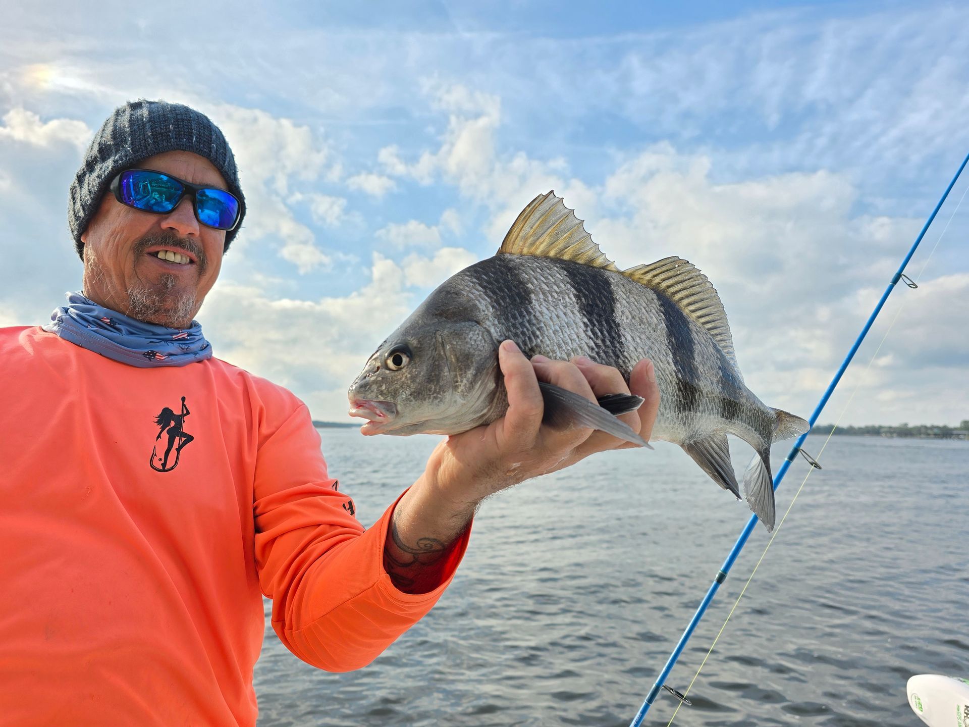 A man is holding a fish in his hand on a boat.