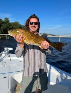 A man is holding a large fish on a boat.