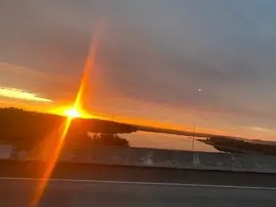 The sun is shining brightly over a body of water.