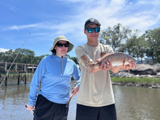 A man and a woman are holding a fish in their hands.