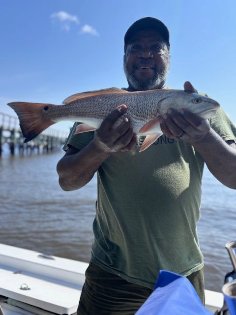 A man is holding a large fish on a boat