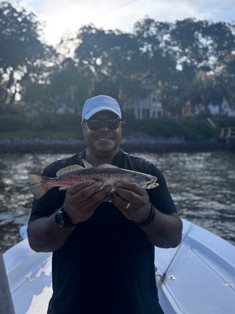 A man on a boat is holding a fish in his hands