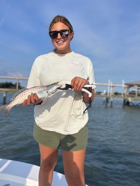 A woman on a boat holding a fish in her hands