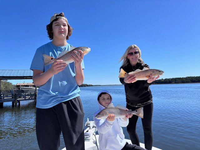 A group of people holding fish on a boat in the water