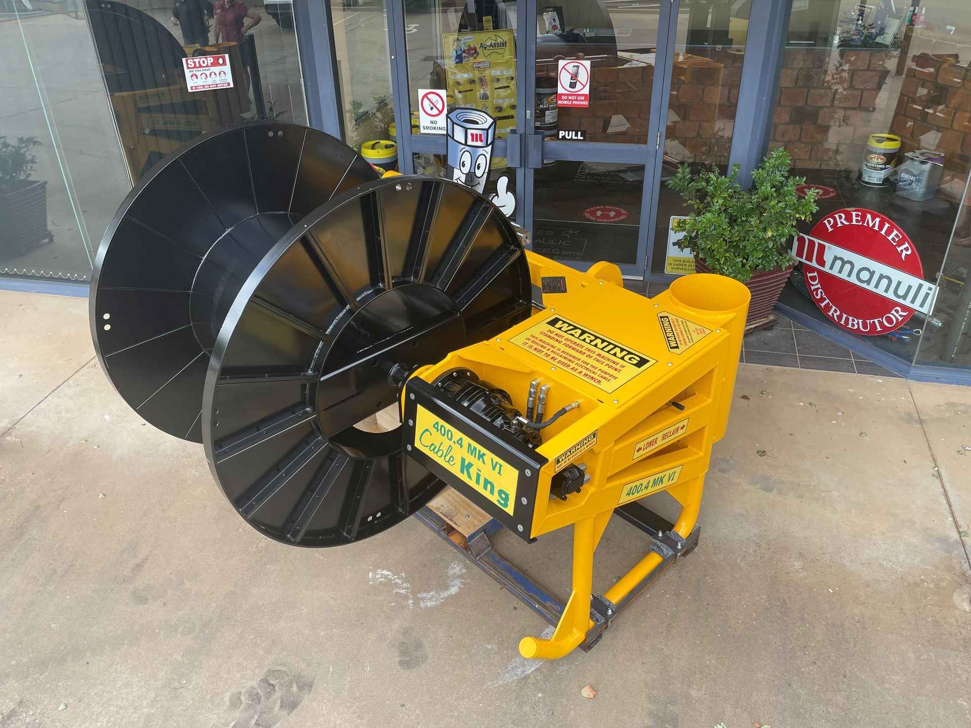 A yellow and black machine is sitting in front of a store