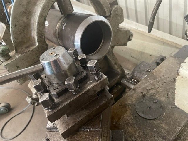 A metal pipe is sitting on top of a machine.