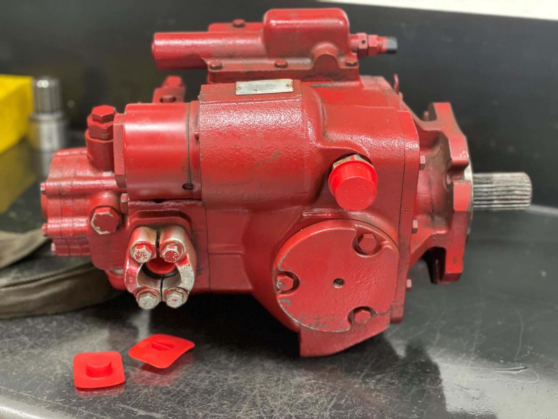A red hydraulic pump is sitting on a counter.