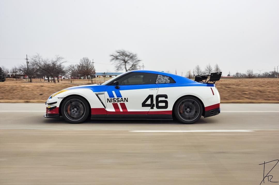 Blue-and-white race car #46 speeding along a track, side view