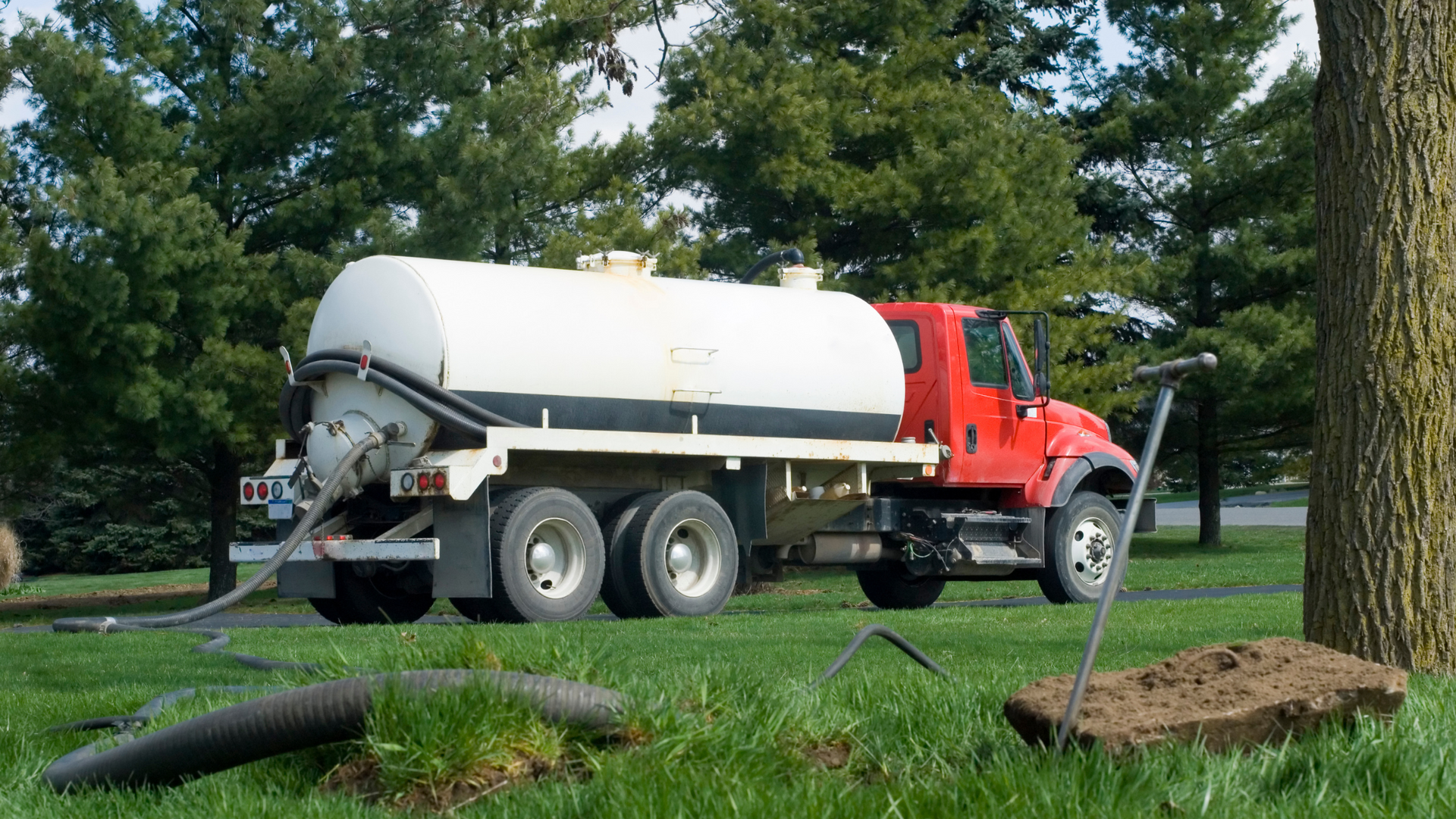 A manhole cover is sitting on the ground next to a drain.