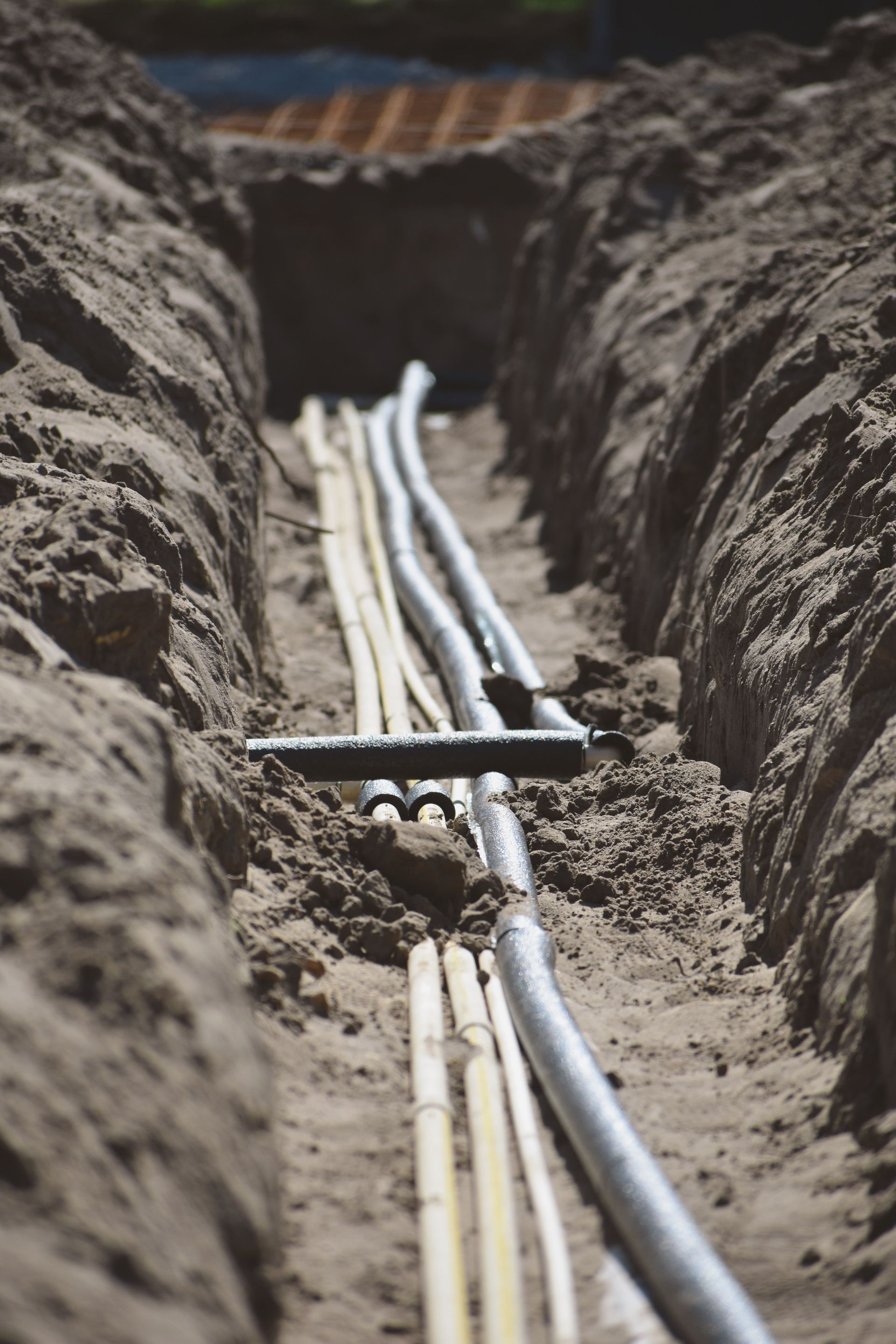 A manhole cover is sitting on the ground next to a drain.