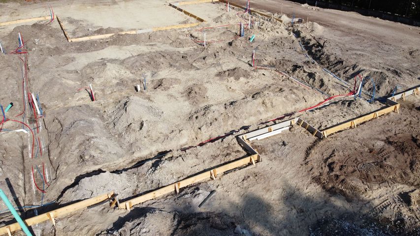 An aerial view of a construction site with a lot of dirt and concrete.