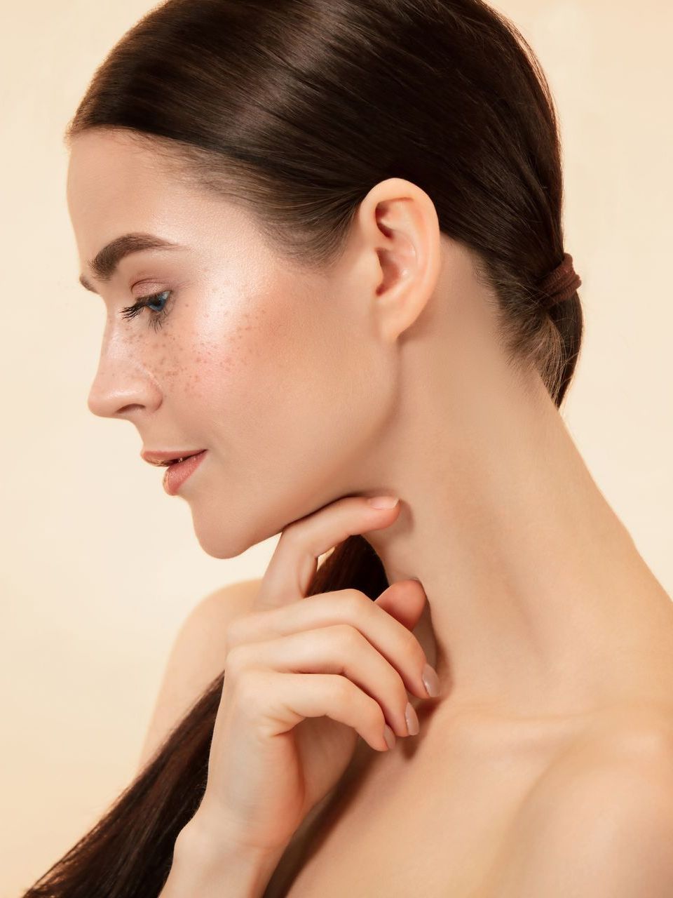 A close up of a woman 's face with her hand on her neck